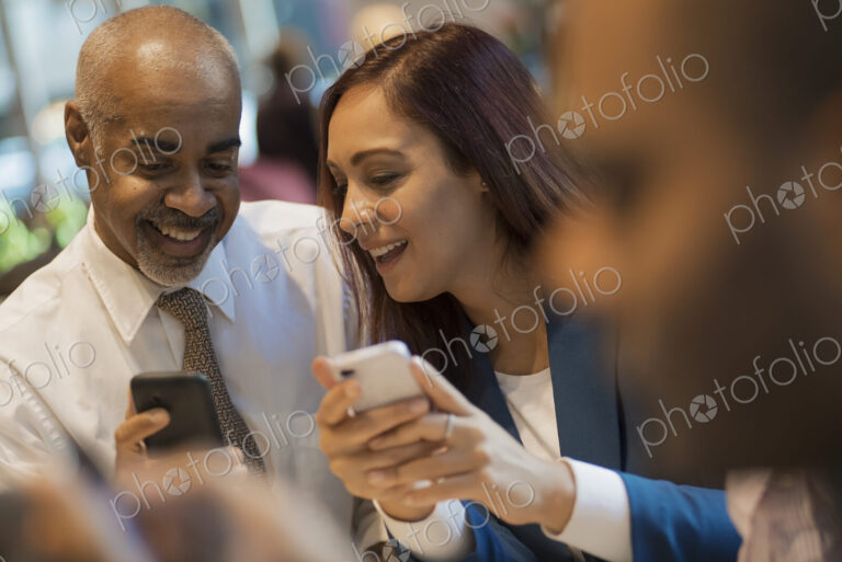 City life. A group of people sitting in a coffee shop, using mobile phones, and…