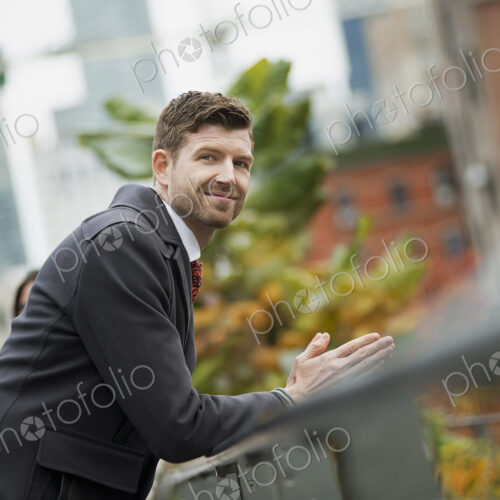 City life. A man in a winter coat leaning on a railing, taking time out. City… City life. A man in a winter coat leaning on a railing, taking time out. City…