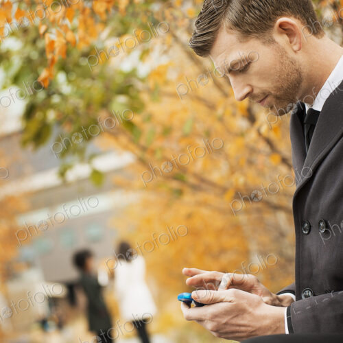 City life. A man in the park checking and texting, keeping in contact, using a mobile… City life. A man in the park checking and texting, keeping in contact, using a mobile…