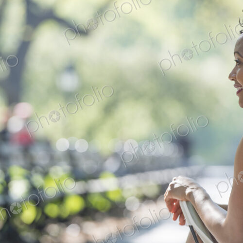 City life. A woman sitting in a camping chair in a city park.