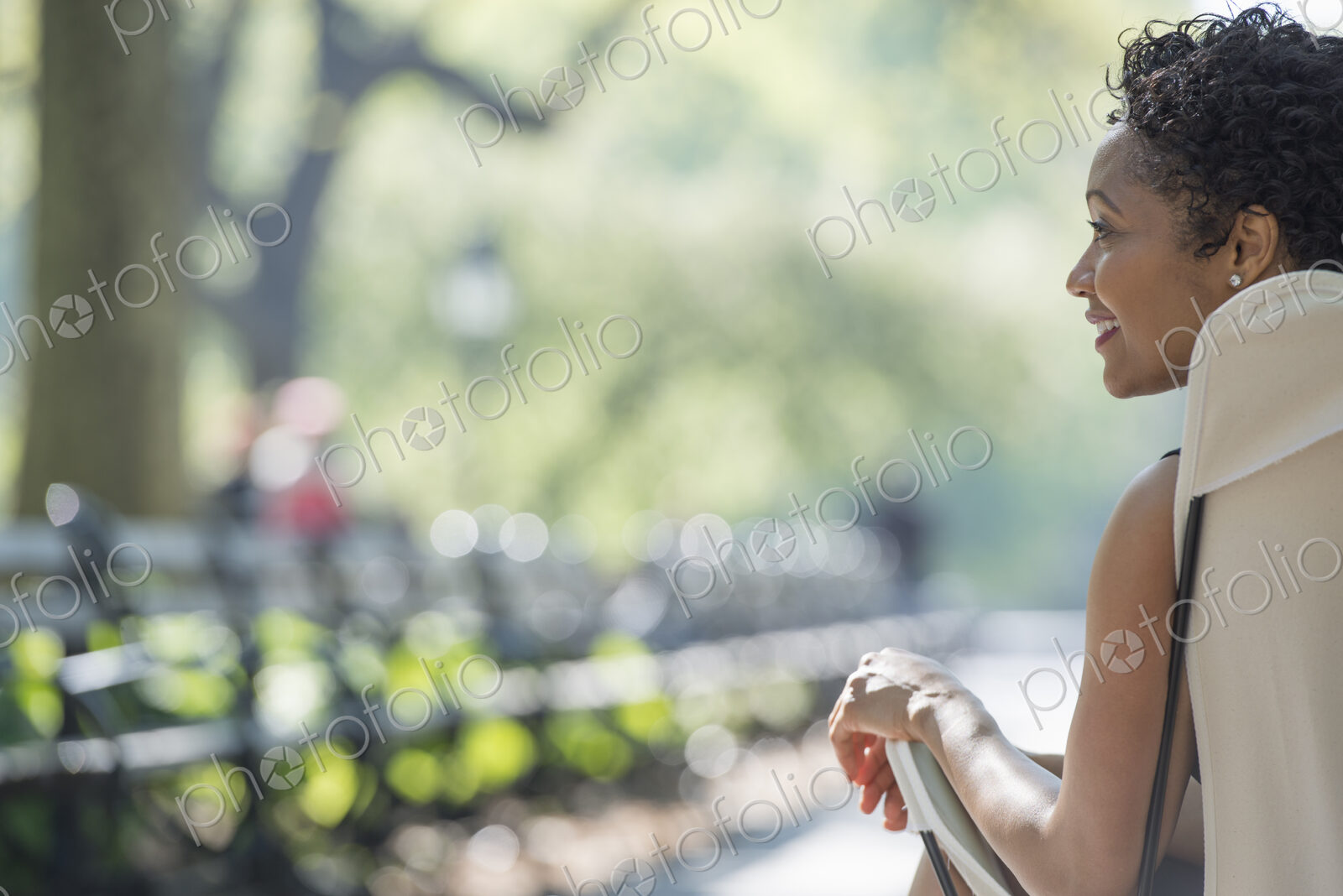 City life. A woman sitting in a camping chair in a city park.