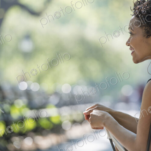 City life. A woman sitting in a camping chair in a city park.