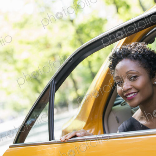 City life. People on the move. A woman getting out of the rear passenger seat of a… City life. People on the move. A woman getting out of the rear passenger seat of a…