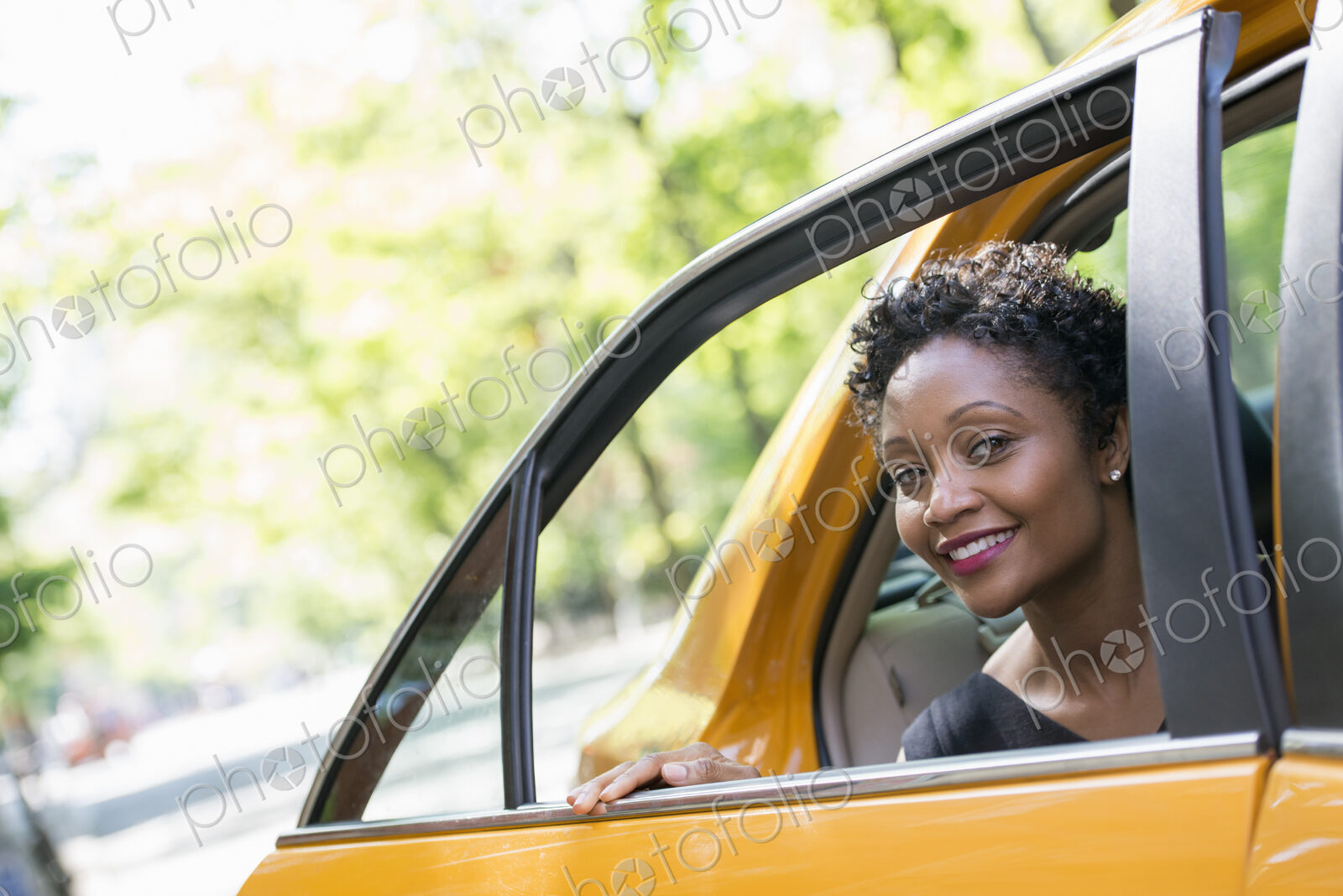 City life. People on the move. A woman getting out of the rear passenger seat of a…