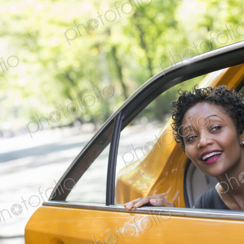 City life. People on the move. A woman getting out of the rear passenger seat of a… City life. People on the move. A woman getting out of the rear passenger seat of a…