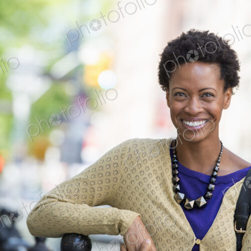 City life. People on the move. A woman in a purple dress, on the city street.