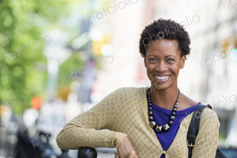 City life. People on the move. A woman in a purple dress, on the city street.