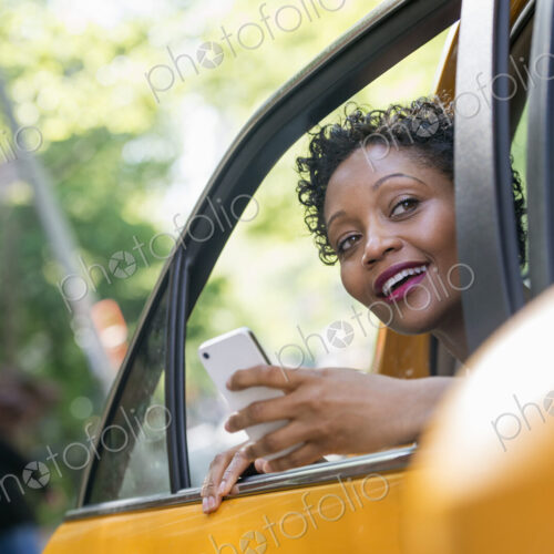 City life. People on the move. A woman sitting in the rear passenger seat of a yellow… City life. People on the move. A woman sitting in the rear passenger seat of a yellow…