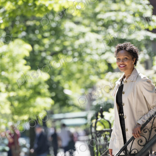 City life. People on the move. A woman walking down steps outside a town house. City life. People on the move. A woman walking down steps outside a town house.