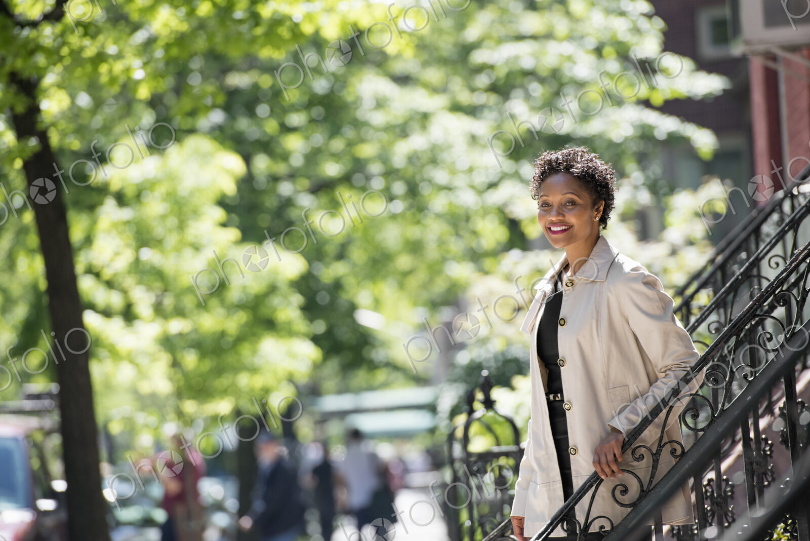 City life. People on the move. A woman walking down steps outside a town house.