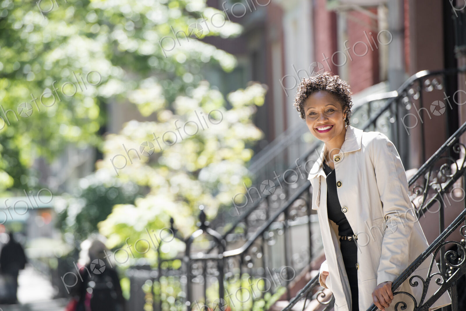 City life. People on the move. A woman walking down steps outside a town house.