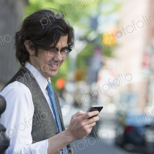 City life. People on the move. A young business man on the street checking his smart… City life. People on the move. A young business man on the street checking his smart…