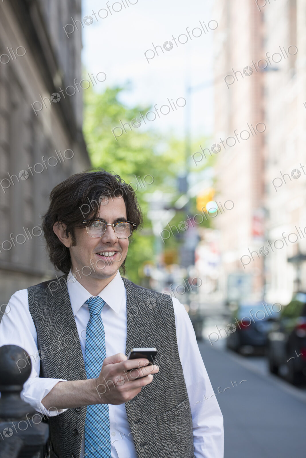 City life. People on the move. A young business man on the street checking his smart…