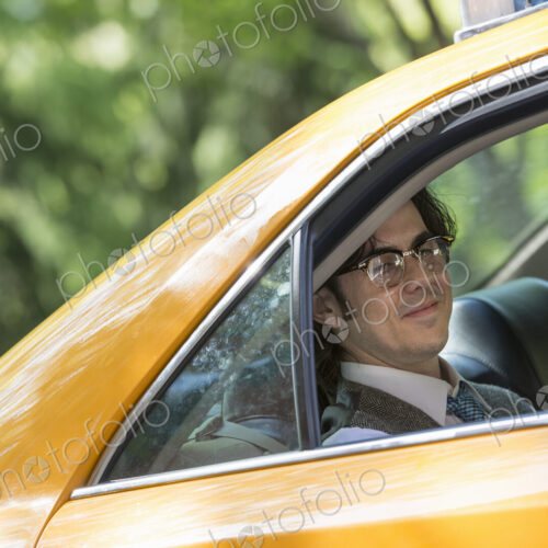 City life. People on the move. A young man in the back seat of a taxi. City life. People on the move. A young man in the back seat of a taxi.