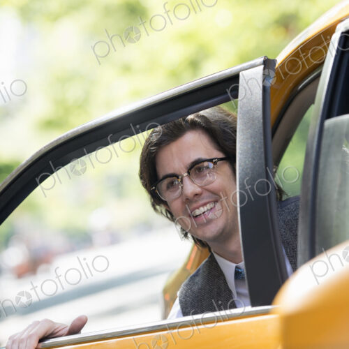 City life. People on the move. A young man in the back seat of a taxi. City life. People on the move. A young man in the back seat of a taxi.