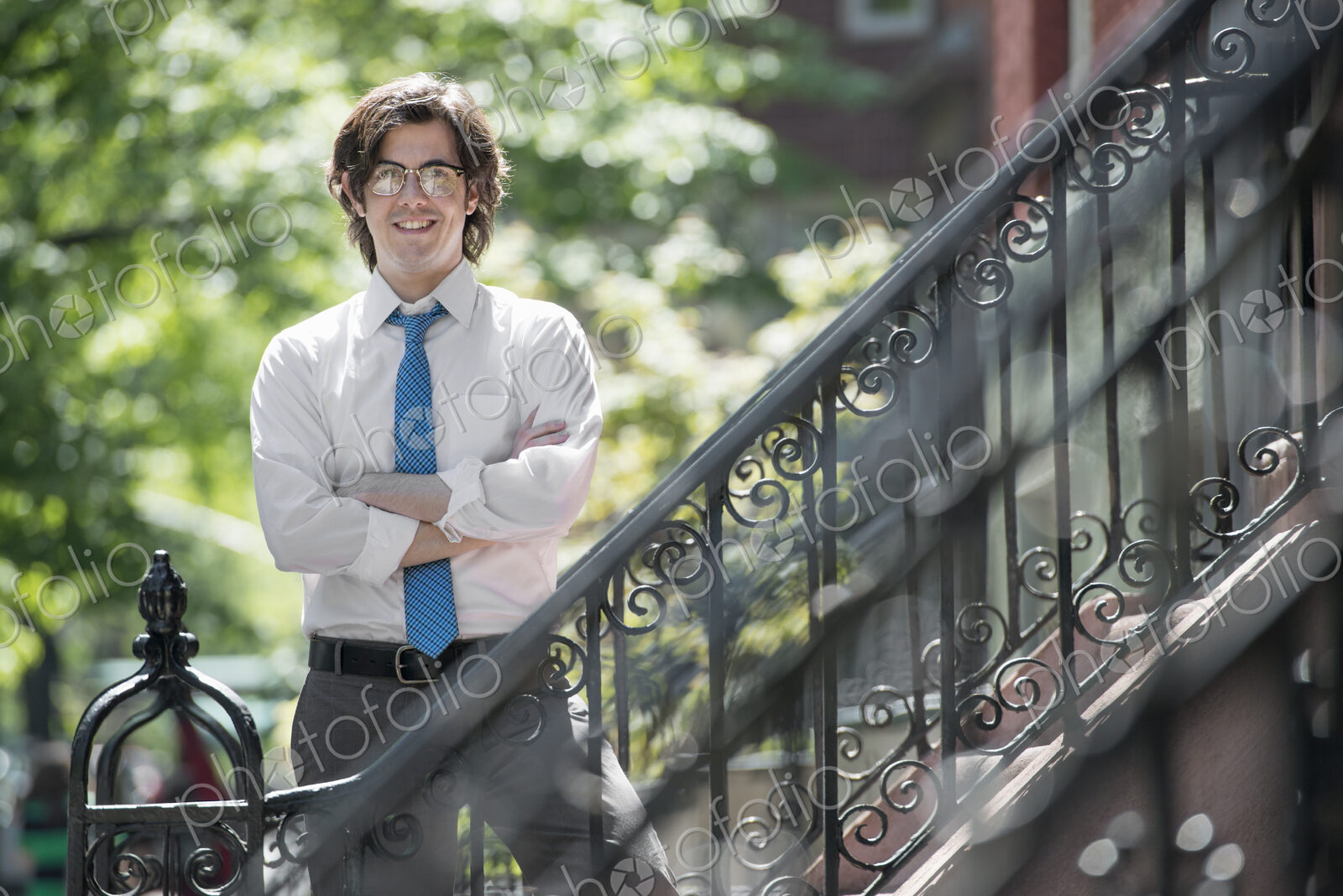 City life. People on the move. A young man in w white shirt and blue tie, standing…