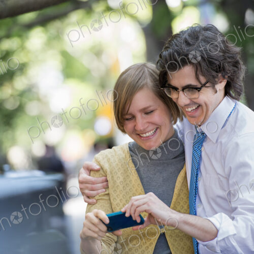 City life. People on the move. Two people, a man and woman outdoors, looking at a… City life. People on the move. Two people, a man and woman outdoors, looking at a…