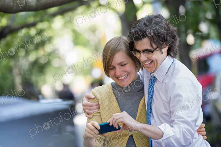City life. People on the move. Two people, a man and woman outdoors, looking at a…