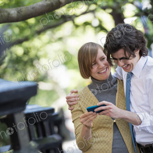 City life. People on the move. Two people, a man and woman outdoors, looking at a… City life. People on the move. Two people, a man and woman outdoors, looking at a…