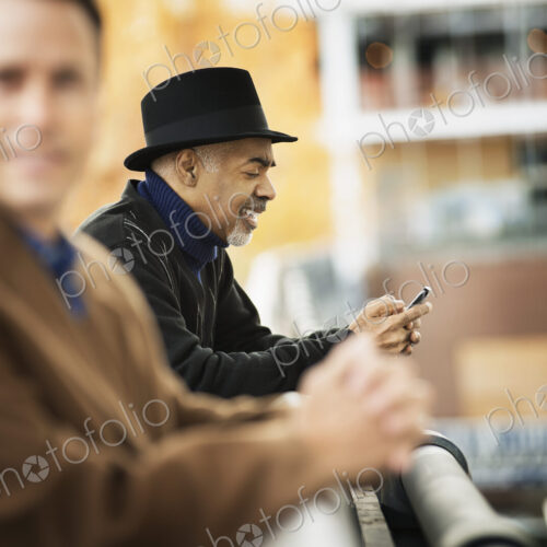 City life. Professional people on the go, keeping in contact, using mobile phones. Two… City life. Professional people on the go, keeping in contact, using mobile phones. Two…