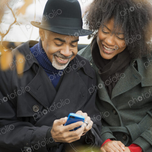 City life. Two people, a man and woman standing side by side, keeping in contact,… City life. Two people, a man and woman standing side by side, keeping in contact,…