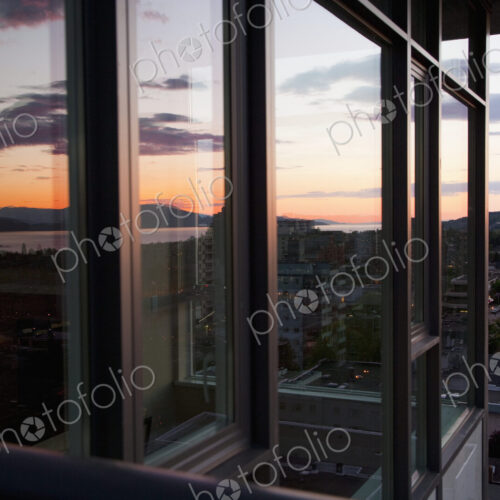 City view at dusk from an open window in an apartment City view at dusk from an open window in an apartment
