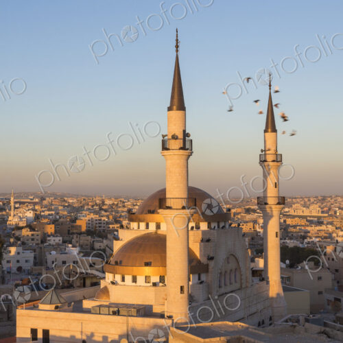 Cityscape at sunset, with mosque and minarets in the foreground. Cityscape at sunset, with mosque and minarets in the foreground.