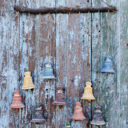 Clay bells hanging from a weathered door