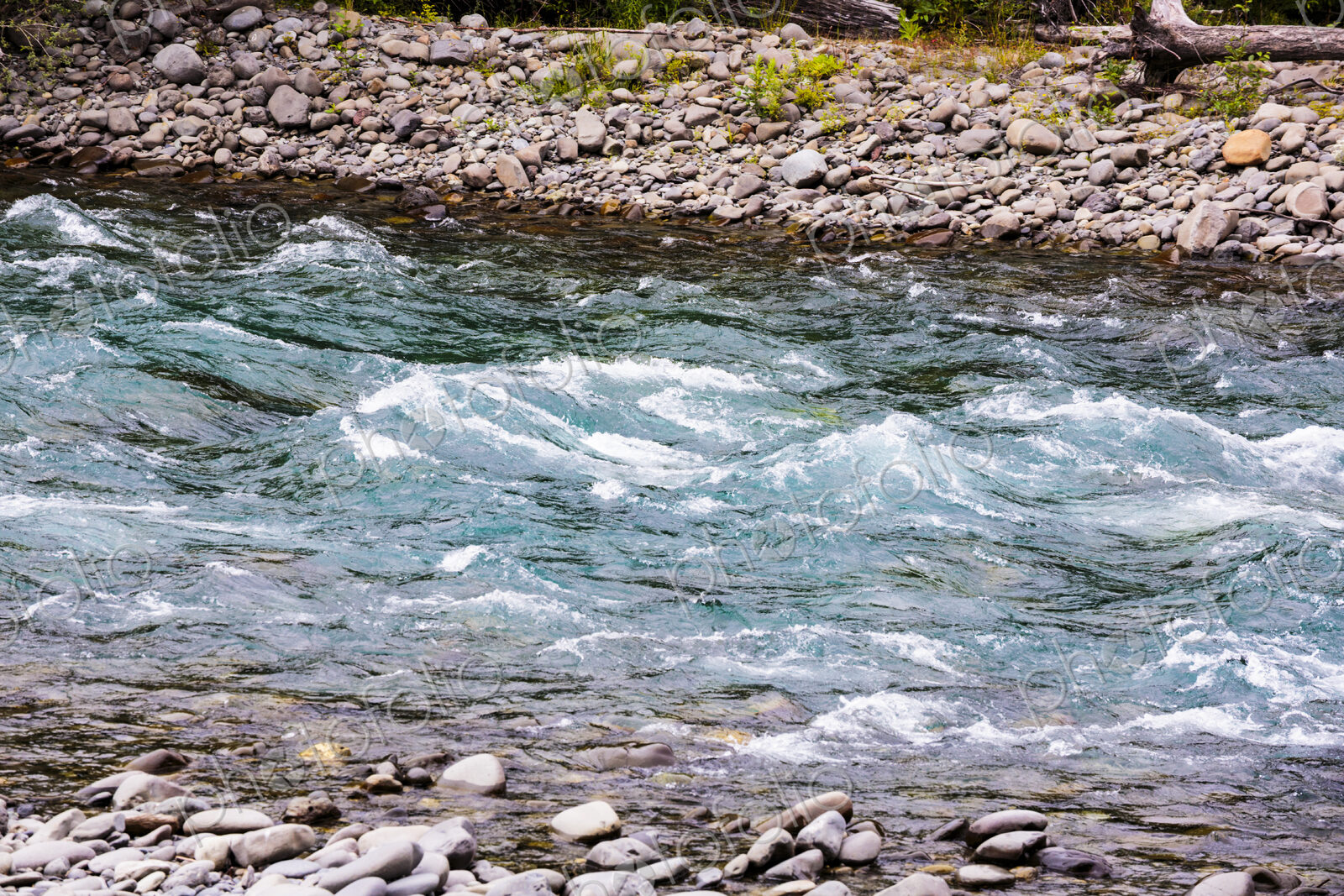 Clear flowing water of a river running over gravel.