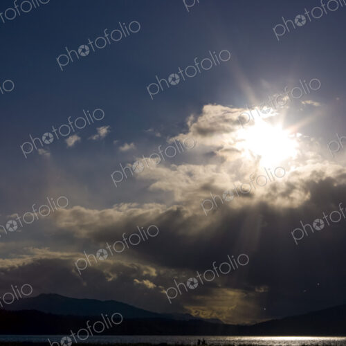 Clearing black storm clouds and a sunburst.