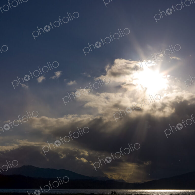 Clearing black storm clouds and a sunburst.