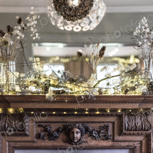 Close up of Christmas decorations on beautifully carved wooden mantelpiece, mirror above. Close up of Christmas decorations on beautifully carved wooden mantelpiece, mirror above.