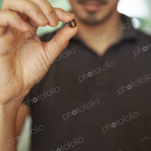 Close up of Japanese man holding roasted coffee bean. Close up of Japanese man holding roasted coffee bean.