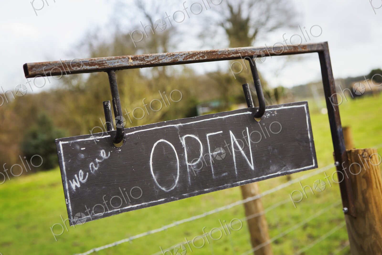 Close up of ‘Open’ sign on a fence at a farm shop.