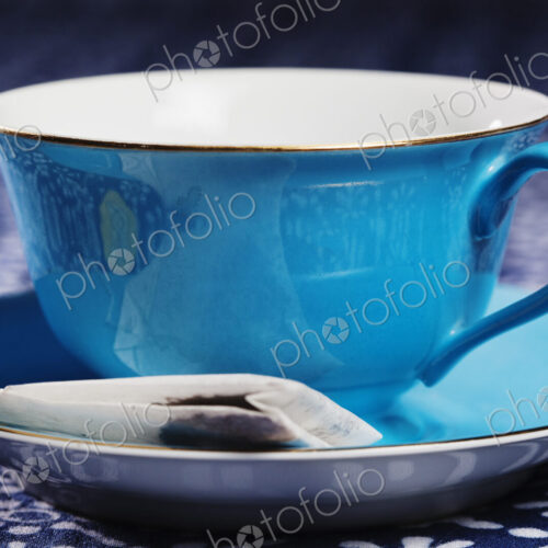Close up of a blue porcelain teacup with matching saucer. Close up of a blue porcelain teacup with matching saucer.