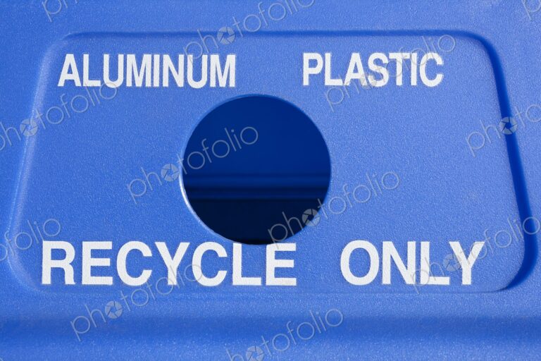 Close-up of a blue recycling bin marked for aluminum and plastic with a circular opening.