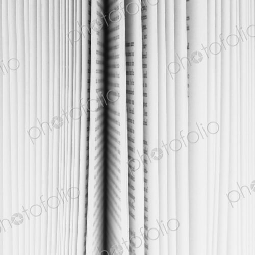 Close up of a book with the pages slightly fanned out, with a black paper edge in the…