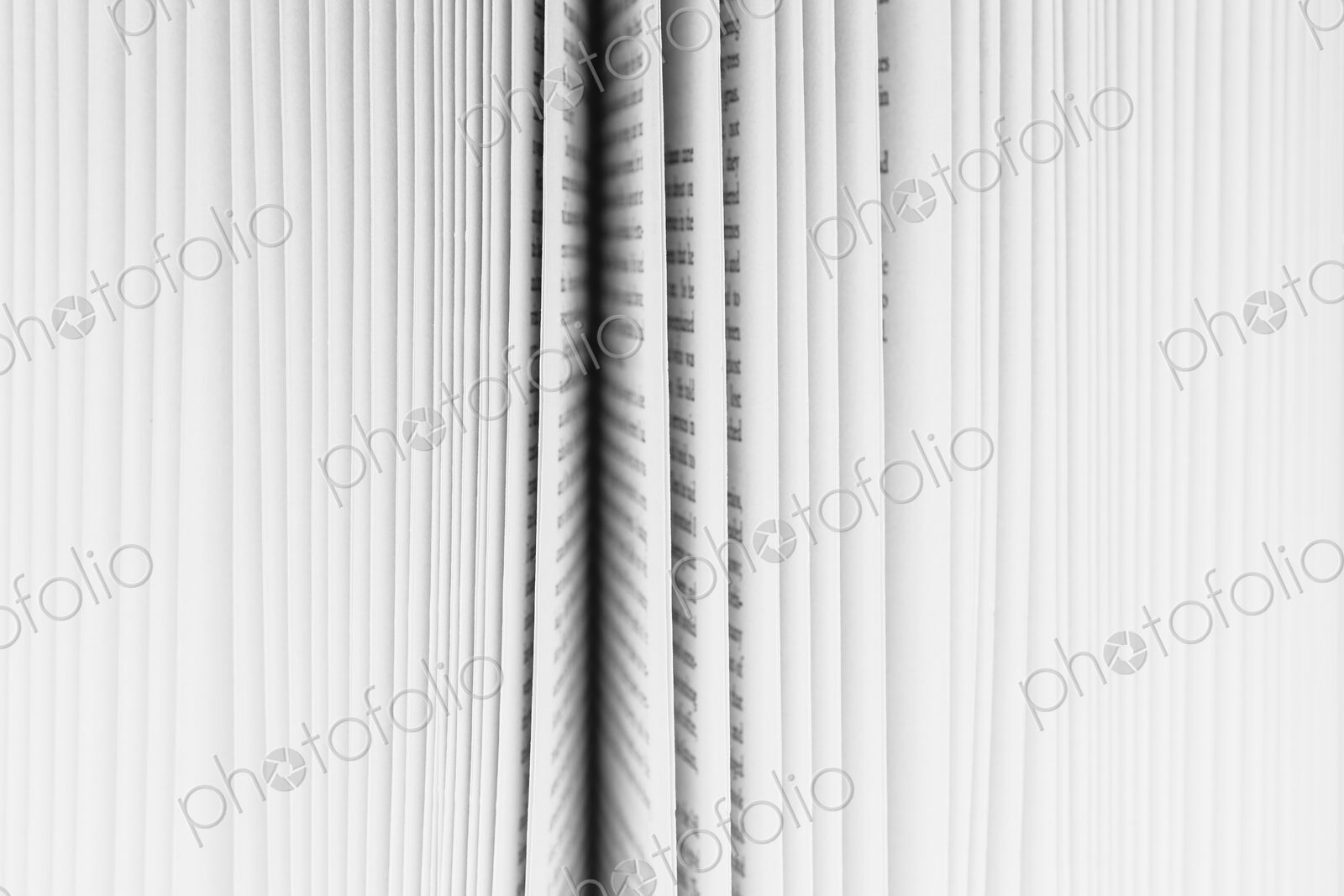 Close up of a book with the pages slightly fanned out, with a black paper edge in the…