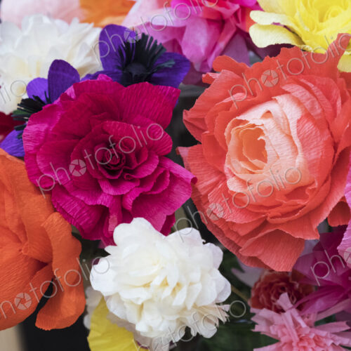 Close up of a bunch of colourful handcrafted fabric flowers.