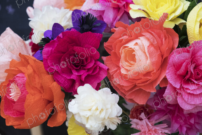 Close up of a bunch of colourful handcrafted fabric flowers.