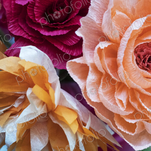 Close up of a bunch of colourful handcrafted fabric flowers.