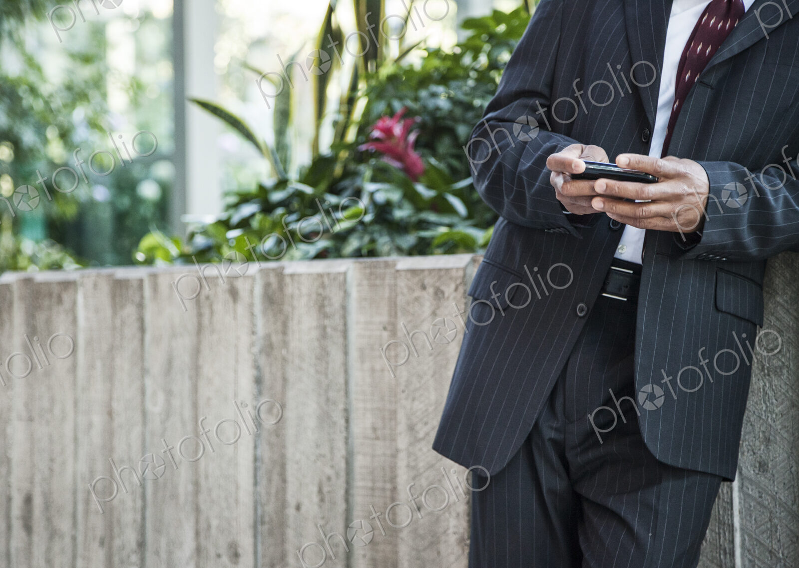 Close-up of a business man texing on a cell phone.