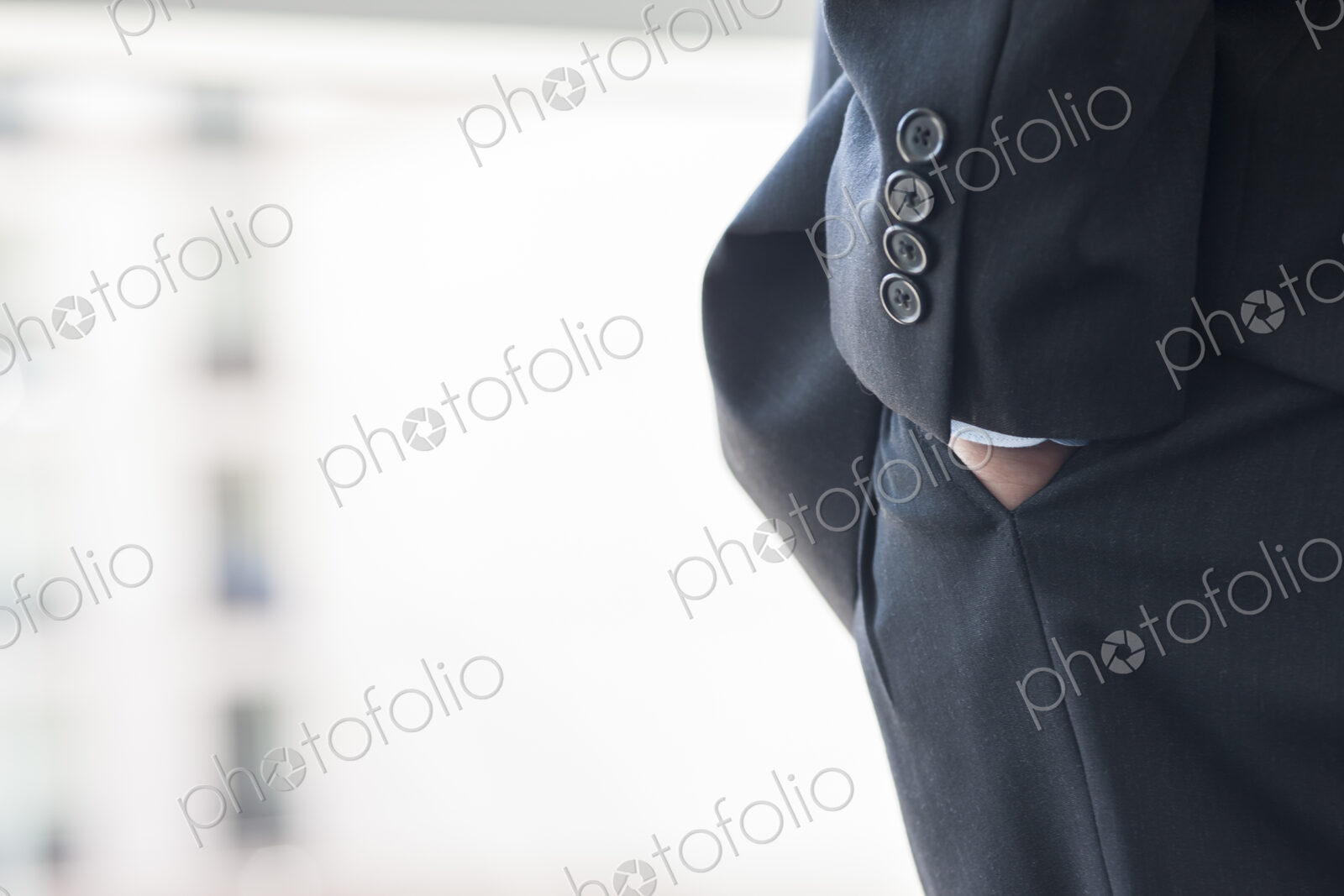 Close-up of a businessman’s hand in a suit pants pocket.