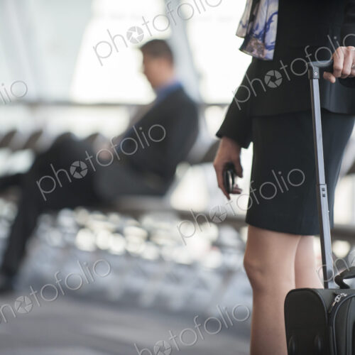 Close-up of a businesswoman's hands on the handle of a luggage carrier in a conference…
