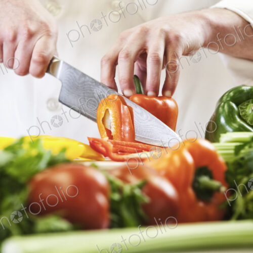 Close-up of a chef using a knife to chop fresh produce, colourful vegetables and bell… Close-up of a chef using a knife to chop fresh produce, colourful vegetables and bell…