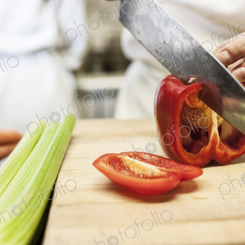 Close-up of a chef using a knife to chop vegetables. Close-up of a chef using a knife to chop vegetables.