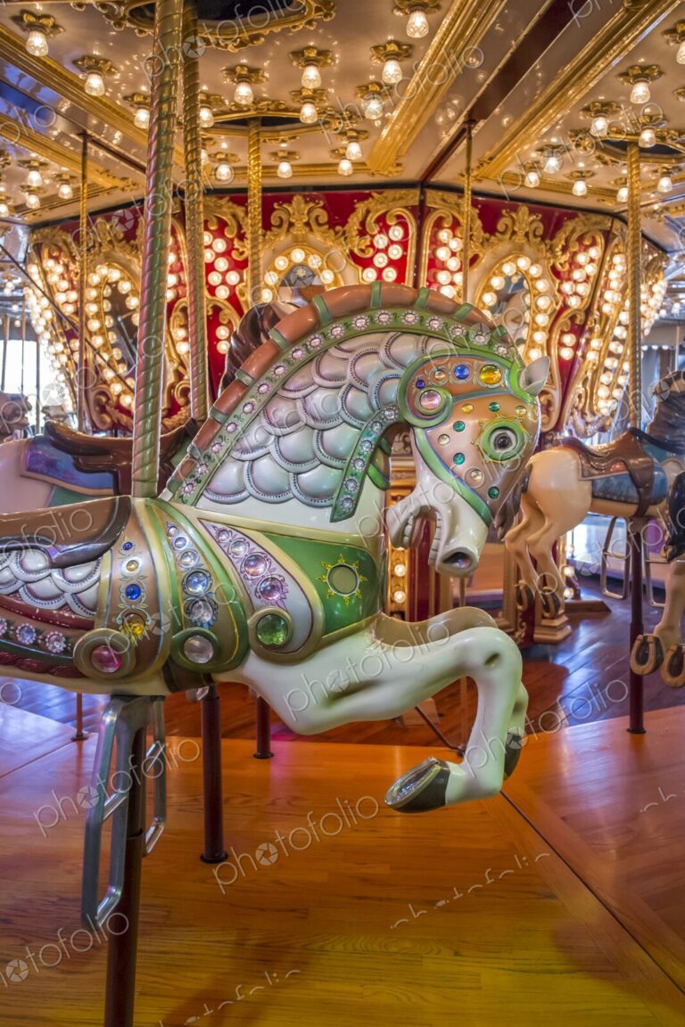 Close-up of a colorful carousel horse on a Merry Go Round decorated with jewels and…