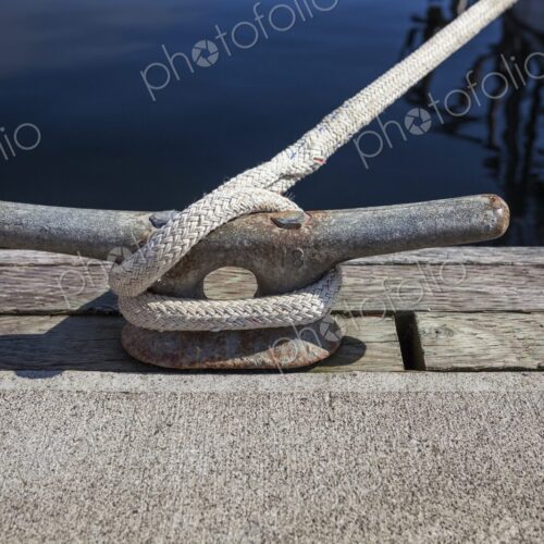 Close-up of a dock cleat with rope securely tied, taken at Charleston Marina in…
