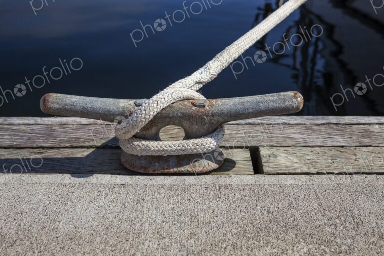 Close-up of a dock cleat with rope securely tied, taken at Charleston Marina in…