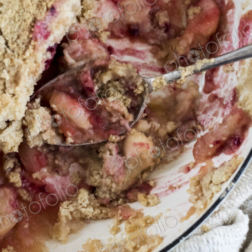 Close up of a freshly baked apple and blueberry crumble dessert.